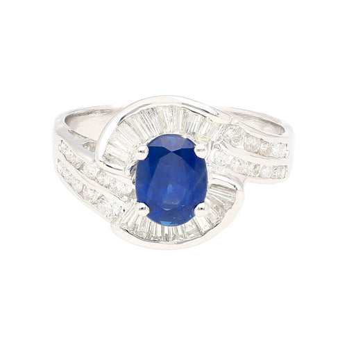 Natural 1.14 Carat Oval Cut Blue Sapphire with Round & Baguette Cut Diamonds in a Swirled 18K White Gold Ring Setting