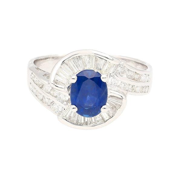 Natural 1.14 Carat Oval Cut Blue Sapphire with Round & Baguette Cut Diamonds in a Swirled 18K White Gold Ring Setting